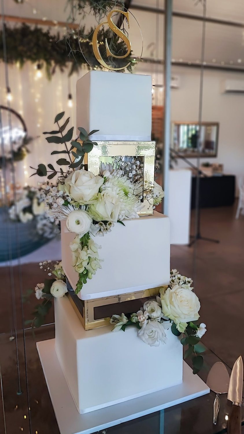 Tall white floral cake on display